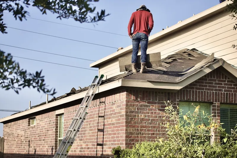 Professional roofer working on a residential roof in Harrington